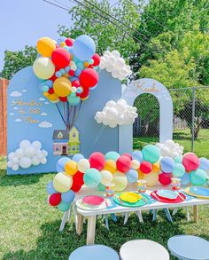 an outdoor birthday party with balloons and plates