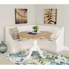 a white bench sitting next to a table on top of a blue and green rug