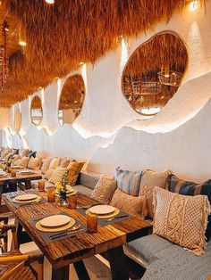 a restaurant with tables and chairs covered in tiki grass that is hanging from the ceiling