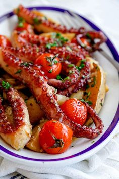 an octopus is served on top of potatoes and tomatoes