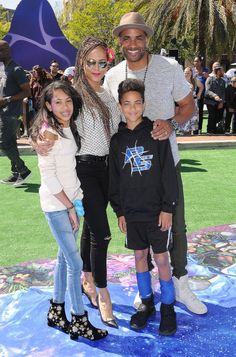 the couple and their children are posing for a photo on the carpet at an event