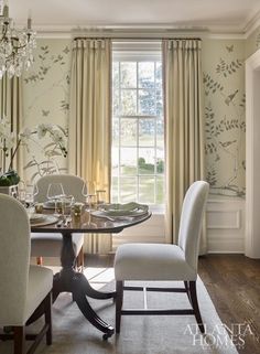 a dining room table with two chairs and a chandelier hanging from the ceiling