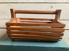 a wooden basket sitting on top of a blue box