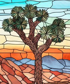 a stained glass window with a tree in the desert