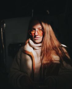 a woman with long red hair wearing glasses