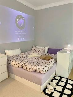 a room with a bed, dresser and projector screen in the wall above it