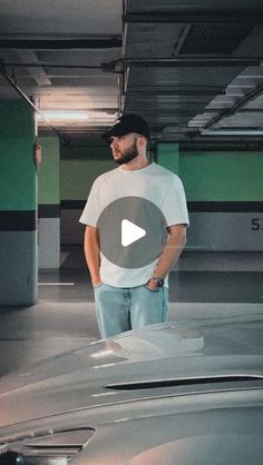 a man standing next to a car in a parking garage