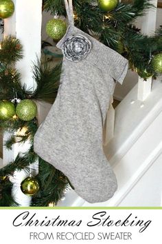 christmas stockings hanging from the banisters with green ornaments on them and white stairs