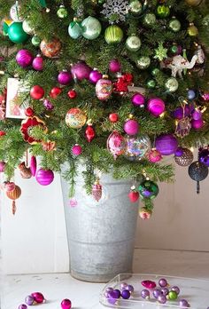 a potted christmas tree with ornaments on it and the words feliz martes