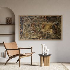 a chair and table in front of a painting on the wall