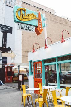 an outdoor cafe with tables and chairs in front of the building that says chicago tacos