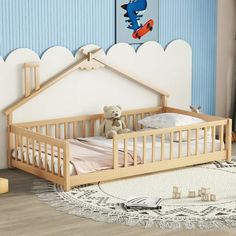 a baby's room with a crib, teddy bear and toys on the floor