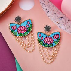 Hi Lovelies,  Make a bold statement with these stunning dangle and drop earrings, perfect for the modern, free-spirited woman. Handcrafted with soft cotton fabric, lustrous pearls, intricate beads, sparkling crystals, and a hand-painted lotus flower design, these earrings are truly unique and eye-catching. The lightweight design ensures comfort for all-day wear, while the long dangle and drop style adds a touch of elegance and sophistication to any outfit. Whether you're dressing up for a special occasion or simply want to elevate your everyday look, these Bohemian style earrings are the perfect addition to your jewelry collection. Painted Necklace, Diy Jewellery Designs, Hand Painted Necklace, Lotus Flower Design, Lotus Earrings, Hand Painted Earrings, Fabric Earrings, Painted Jewelry, Hand Painted Jewelry