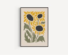 a yellow and black flower with leaves on it in a white frame hanging on the wall