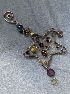 a star shaped brooch with many different colored beads on it's back end