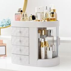 a white counter topped with lots of different types of cosmetics and perfume bottles next to a mirror