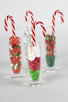 candy canes and candies in glass vases on white background