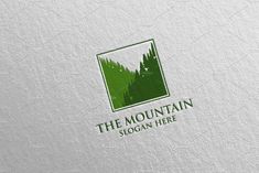 the mountain logo is shown on a white paper sheet with green trees in the background