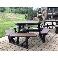 several picnic tables and benches on a brick patio