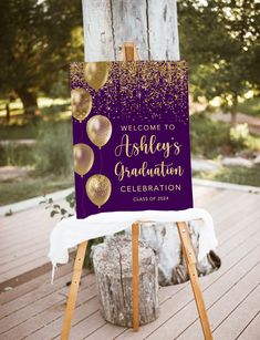 a purple and gold celebration welcome sign on an easel