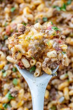 a spoon full of macaroni and cheese with meat