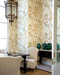 a dining room with wall paper and chairs