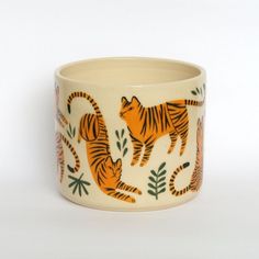 a ceramic cup with tiger designs on it