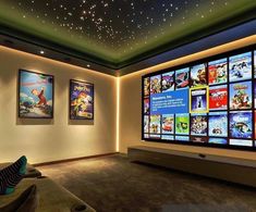 a home theater with many movie posters on the wall and ceiling lights in front of it