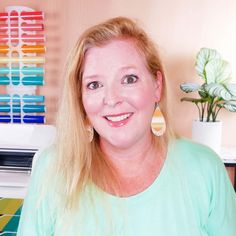 a woman with long blonde hair wearing earrings