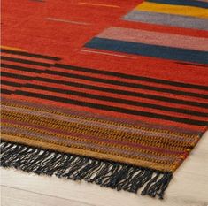 a multicolored rug with fringes on the floor