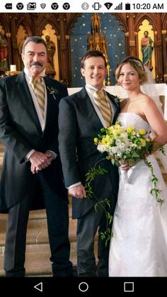 two men and a woman standing in front of a church alter with flowers on their wedding day