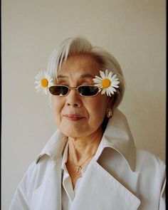 an old woman with sun glasses and daisies in her hair