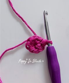 the crochet hook has been hooked up to an umbrella with a purple handle