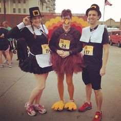 three people dressed up in costumes posing for a photo at a race with the number twenty seven on their feet