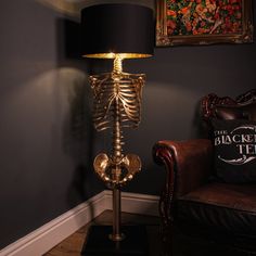 a skeleton lamp sitting on top of a table next to a chair