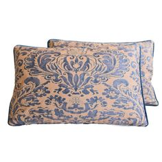 two blue and beige pillows with an ornate design on the front, one is made out of