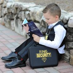 a young boy sitting on the ground reading a book