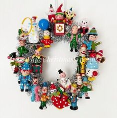 a christmas wreath hanging on the wall with ornaments and decorations around it's edges