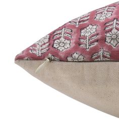 a close up of a pillow on top of a white surface with a pink flower pattern