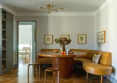 a table with two chairs and a bench next to it in a room that has wood floors