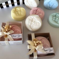 four soaps in small boxes with ribbons around them