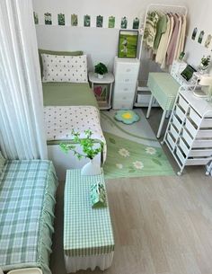 a small bedroom with green and white decor on the walls, furniture and bedding