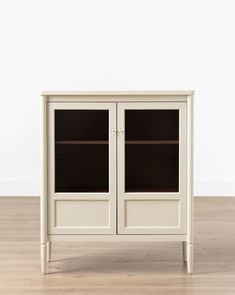 a white cabinet sitting on top of a hard wood floor