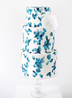 a three tiered cake with blue flowers on it