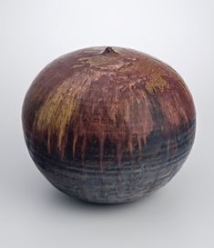 a brown and black vase sitting on top of a table