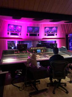 a recording studio with sound mixing equipment and purple lighting