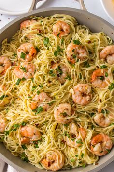 pasta with shrimp and parsley in a skillet on a white tablecloth, ready to be eaten