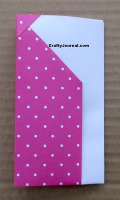 a pink and white polka dot paper with a tie on the bottom half of it