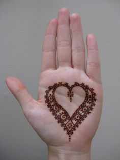 a person's hand with a heart shaped hendi design on it, showing the inside of their palm