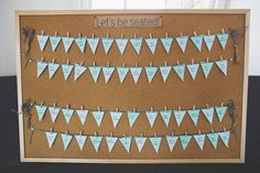 a bulletin board with paper pennants attached to it and the words let's be seated